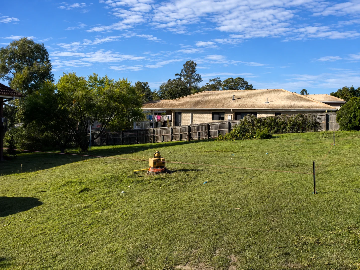 Pre-construction site set-out with laser level, string lines and stakes at the Oxley property — 8 June 2025 · Before construction · Site set-out