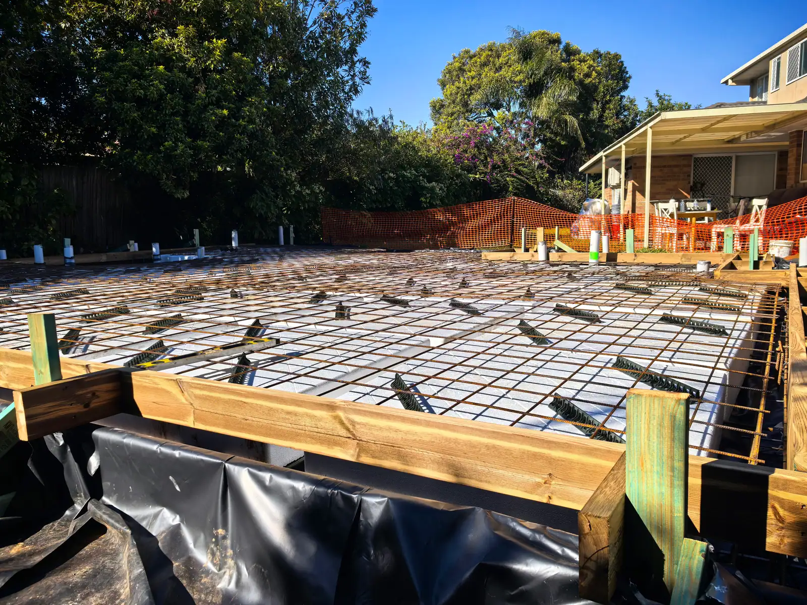 Steel reinforcement mesh and timber formwork in place across the slab area before the concrete pour — 7 August 2026 · Foundation · Structural inspection completed